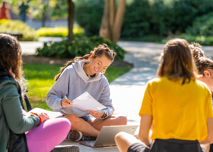 Student sit outside while doing homework.