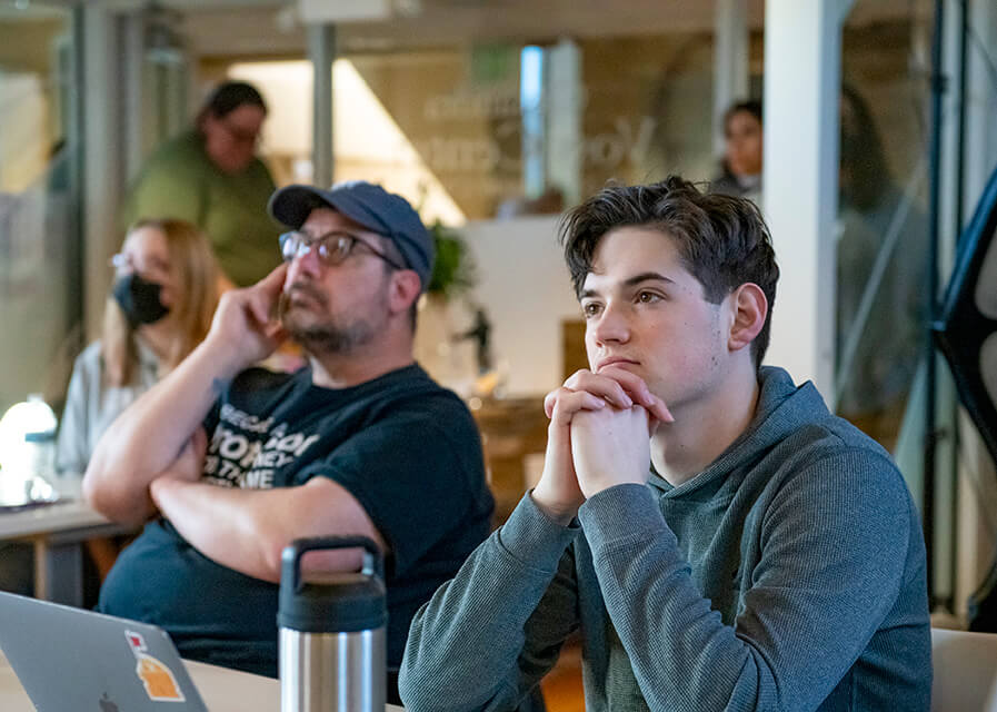 A St. Norbert College student sits beside a faculty member during a presentation.