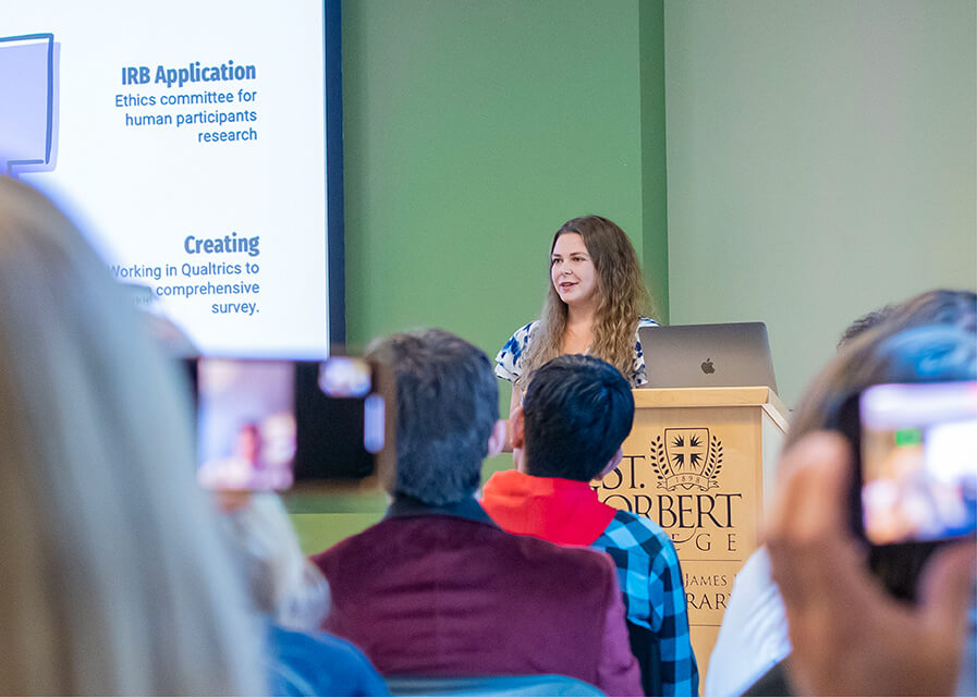 Student presents in front of an audience