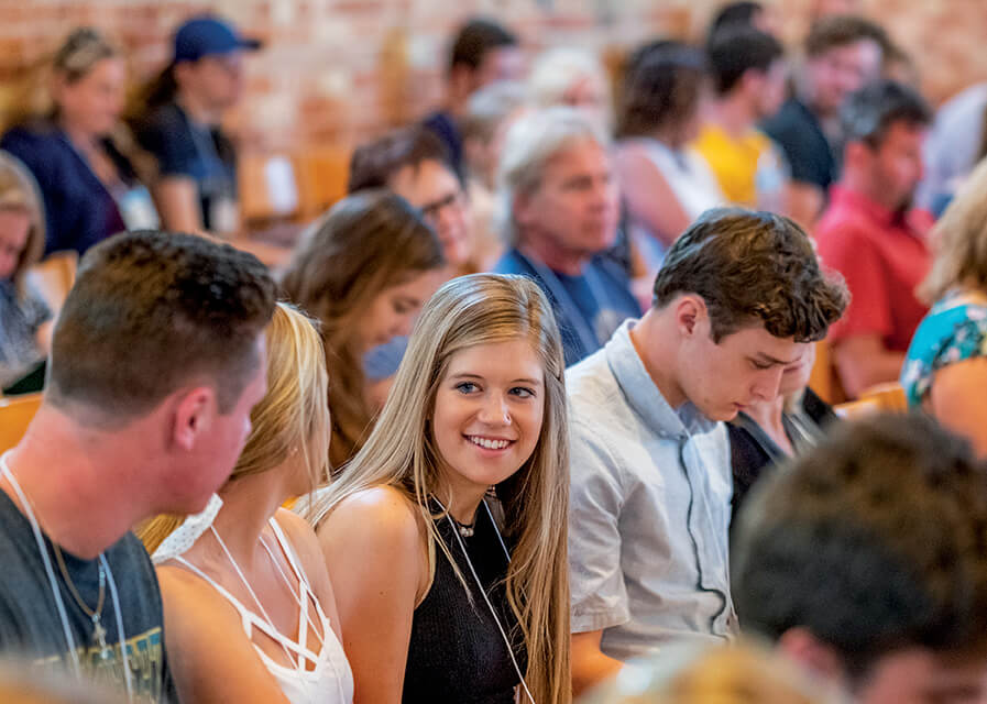 Students listening to a presentation and smiling