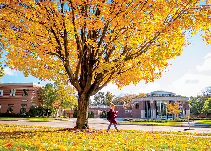 Student walking across the street of the Michels Common