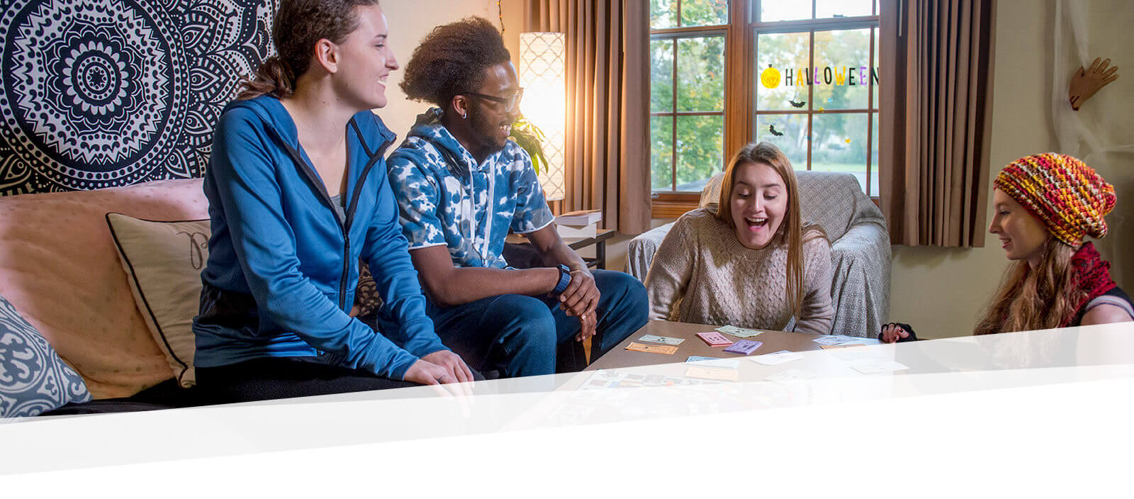 Students gather around and talk a table in a dorm room